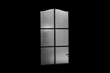 Dark silhouette of glass door in supernatural light. Locked alone in room behind door on Halloween. Nightmare with aliens, monsters and ghosts. Evil in home. Inside haunted house. Alone in dark.