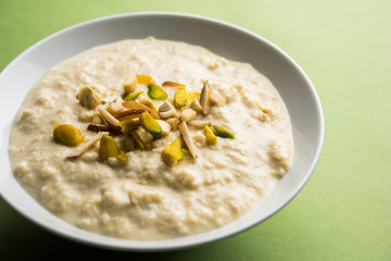 Sweet Rabdi or Lachha Rabri or basundi, made with pure milk garnished with dry fruits. Served in a bowl over moody background. Selective focus