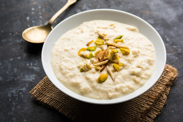 Sweet Rabdi or Lachha Rabri or basundi, made with pure milk garnished with dry fruits. Served in a bowl over moody background. Selective focus