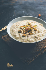 Sweet Rabdi or Lachha Rabri or basundi, made with pure milk garnished with dry fruits. Served in a bowl over moody background. Selective focus