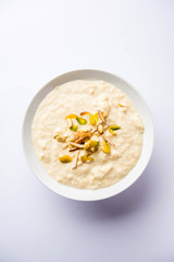 Sweet Rabdi or Lachha Rabri or basundi, made with pure milk garnished with dry fruits. Served in a bowl over moody background. Selective focus