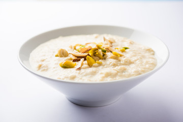 Sweet Rabdi or Lachha Rabri or basundi, made with pure milk garnished with dry fruits. Served in a bowl over moody background. Selective focus