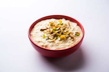 Sweet Rabdi or Lachha Rabri or basundi, made with pure milk garnished with dry fruits. Served in a bowl over moody background. Selective focus