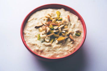 Sweet Rabdi or Lachha Rabri or basundi, made with pure milk garnished with dry fruits. Served in a bowl over moody background. Selective focus