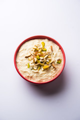 Sweet Rabdi or Lachha Rabri or basundi, made with pure milk garnished with dry fruits. Served in a bowl over moody background. Selective focus