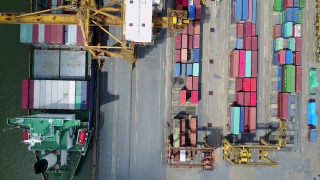 4K. Logistics and transportation of container cargo freight ship with container crane in shipyard. Logistic import export business and transport industry. Aerial view taken from drone.