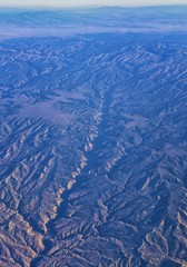 Aerial view of topographical Rocky Mountain landscapes on flight over Colorado and Utah during autumn. Grand sweeping views of rivers, mountain and landscape patterns. Top view, Rockies and Wasatch Fr
