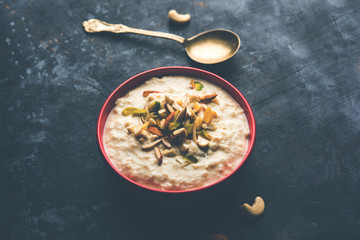 Sweet Rabdi or Lachha Rabri or basundi, made with pure milk garnished with dry fruits. Served in a bowl over moody background. Selective focus