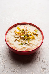 Sweet Rabdi or Lachha Rabri or basundi, made with pure milk garnished with dry fruits. Served in a bowl over moody background. Selective focus