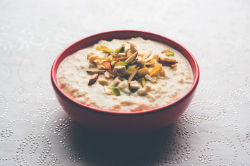 Sweet Rabdi or Lachha Rabri or basundi, made with pure milk garnished with dry fruits. Served in a bowl over moody background. Selective focus