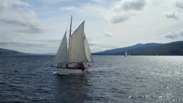 Stunning round the bow aerial shot of a thirties gaff ketch off Mull, Scotland