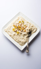 Sweet Rabdi or Lachha Rabri or basundi, made with pure milk garnished with dry fruits. Served in a bowl over moody background. Selective focus