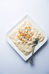 Sweet Rabdi or Lachha Rabri or basundi, made with pure milk garnished with dry fruits. Served in a bowl over moody background. Selective focus