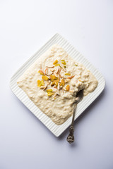 Sweet Rabdi or Lachha Rabri or basundi, made with pure milk garnished with dry fruits. Served in a bowl over moody background. Selective focus