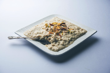 Sweet Rabdi or Lachha Rabri or basundi, made with pure milk garnished with dry fruits. Served in a bowl over moody background. Selective focus