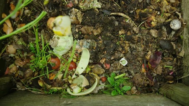 Slow motion shot of compost being added to the heap