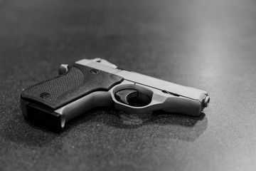 Small Silver Handgun Isolated on Dark Table
