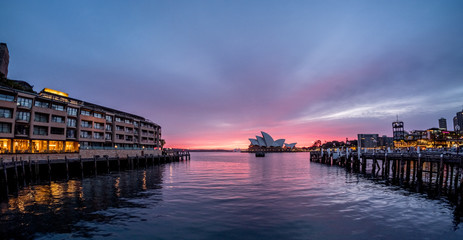 Hotel, pier and Opera House on Sydney Harbour at dawn