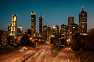 Car traffic flowing towards city skyline, after sunset. Summer evening in Atlanta, USA.