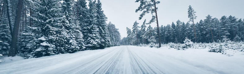 winter road, covered with snow on sunny day. Black icy asphalt