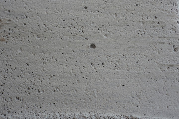 Close-up porous pattern of white concrete surface.