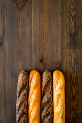 Baguettes. White and brown on dark wooden background top view copy space