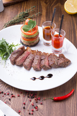 Fried juicy beef steak served with grilled vegetables and spicy sauces