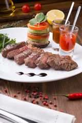 Fried juicy beef steak served with grilled vegetables and spicy sauces
