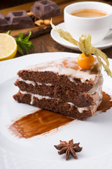 Slice of chocolate cake served with cupt tea and mint