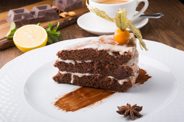 Slice of chocolate cake served with cupt tea and mint