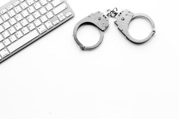 Cyberfraud concept. Handcuff near keyboard on white background top view copy space
