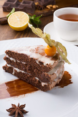 Slice of chocolate cake served with cupt tea and mint