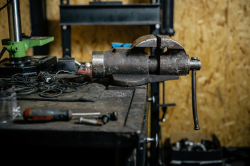 Damaged old used vise grip on blacksmith table