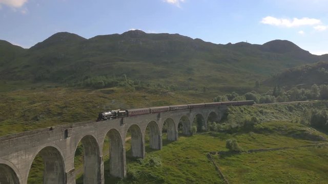 Aerial view of Steam Train crossing Glenfinnan Viaduct Scotland
