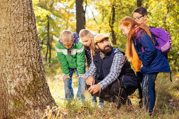 Trip to the forest. Nice positive children looking down while looking for mushrooms in the forest