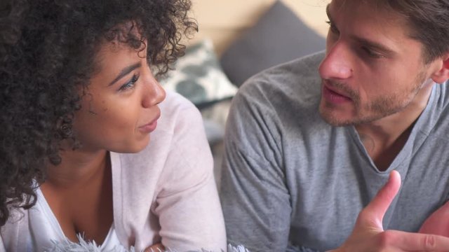 Mixed race couple talking in bed