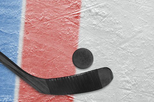 Hockey stick, puck and ice arena fragment with red and blue lines