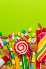 Fototapeta premium Colorful candies on green background