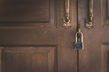 Old wooden door with lock for key with silver.