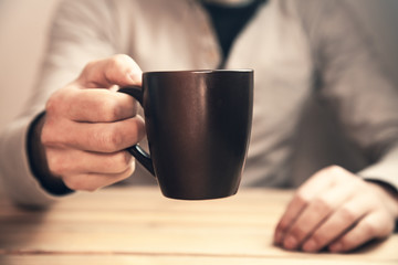 Man holding coffee cup.