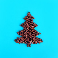 Christmas tree made from coffee beans on a blue background, top view.