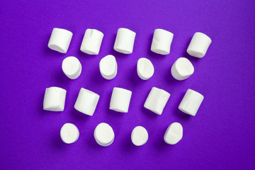 marshmallow laid out on violet paper background.