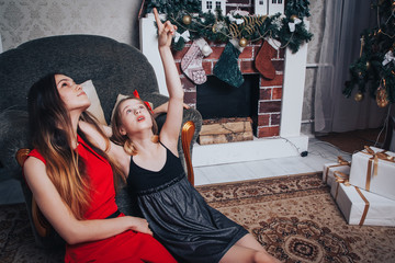 Two girls sisters have relax and fun in a room decorated for Christmas and the New year