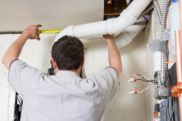 Plumber Measuring Pipe