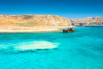 Obraz premium Rusting shipwreck at the seaside near The Balos lagoon at northwest from island of Crete, Greece.