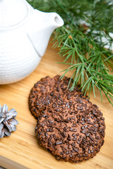 Delicious cookies with chocolate crumbs. Tasty dessert food in close up. Chocolate cookies served on tray, decorated fir branches. French cuisine. Christmas theme