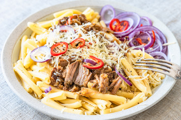 Pasta genovese - casarecce with genovese-style beef sauce in a white plate on rustic background