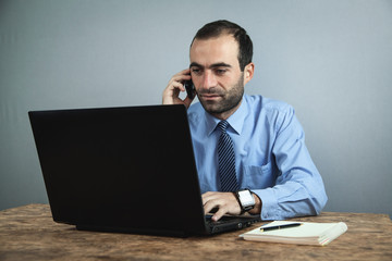 Businessman talking phone and working on laptop. Business concept