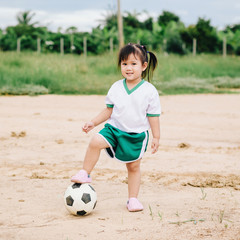 An asian kid playing soccer football for exercise which is a good for children to decrease the overweight or obese.