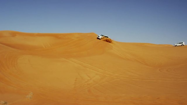Aerial Dubai Drone view of Desert vehicles dune bashing 